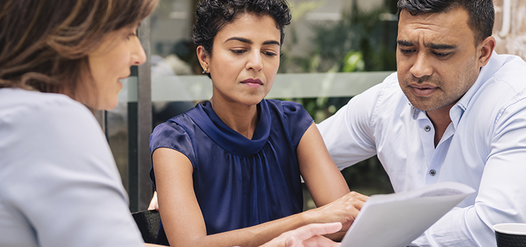 Three people reviewing documetns